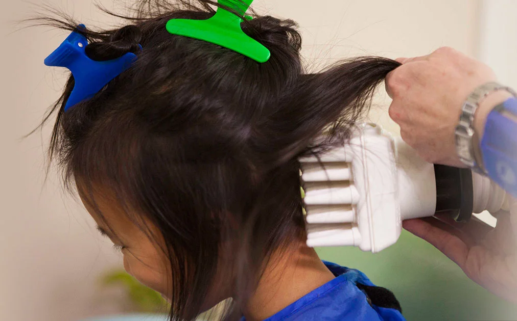 child receiving AirAlle treatment for head lice